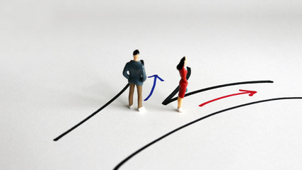 The concept of gender division. A miniature man and a miniature woman on their way to another...