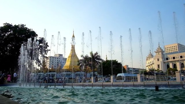 YANGON, MYANMAR - FEBRUARY 15, 2018: The Maha Bandula Garden in Downtown boasts beautiful refreshing fountains, opening the view on golden Sule Pagoda, on February 15 in Yangon.