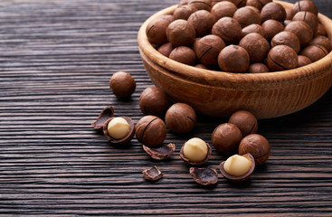 Macadamia nuts in wooden bowl   on brown wooden table