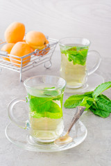Hot tea with mint leaves in transparent glasses on the table
