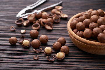 Macadamia nuts in wooden bowl   on brown wooden table