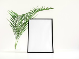 Front view blank mock up of photo frame on white background, tropical palm leaves. Summer concept. Flat lay, top view, copy space 