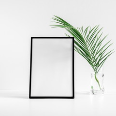 Front view blank mock up of photo frame on white background, tropical palm leaves. Summer concept. Flat lay, top view, copy space 