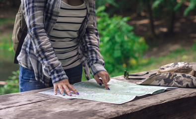 Hands woman on tourist map. Woman is planning route.