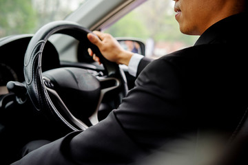 Successful businessman sitting behind the wheel of a car