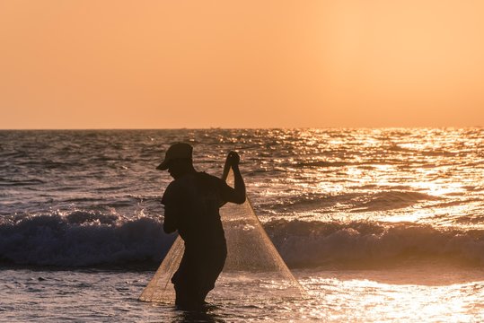 Local fishermen with fishing net in backlight, sunset, Chaung Thar Beach, Bay of Bengal, Ayeyarwady, Myanmar, Asia