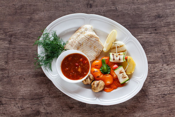 grilled fish fillet served with vegetables and sauce