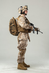 Soldier in camouflage holding rifle