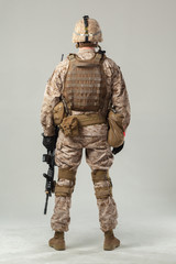 Soldier in camouflage holding rifle