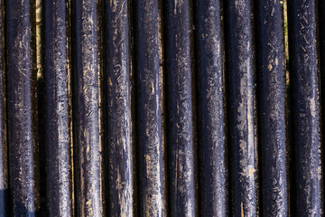 Fototapeta premium Oil Drill pipe. Rusty drill pipes were drilled in the well section. Downhole drilling rig. Laying the pipe on the deck. View of the shell of drill pipes laid in courtyard of the oil and gas warehouse.