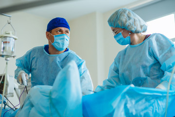 Male surgeon's holing the instrument in abdomen of patient. Female assistant help him. The surgeon's doing laparoscopic surgery in the operating room. Minimally invasive surgery. Close up