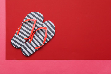 Summer beach flip flops on colored background