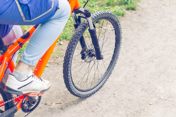 Naklejka premium Cyclist on an orange bike riding a bicycle path