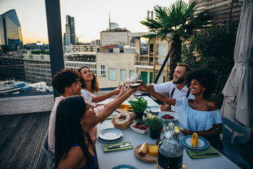Group of friends having fun on the rooftop of a beautiful penthouse