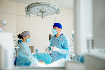 The surgeon's holing the instrument in abdomen of patient. The surgeon's doing laparoscopic surgery...