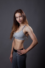 fitness trainer relaxed posing on grey background