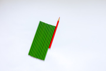 Concept: 12 green not ground pencils and 1 ground red on a white isolated background