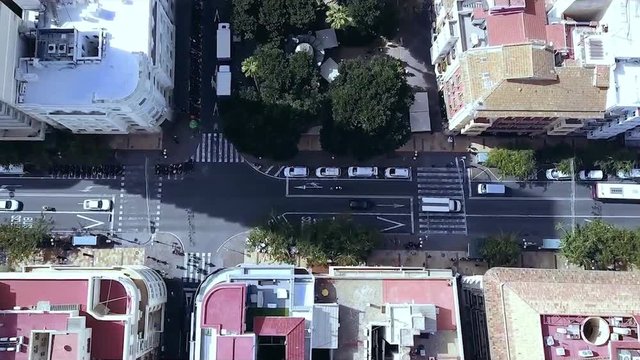 Urban aerial view of road towards intersection showing urban roads crossing each other traffic driving over roads and traffic lights. Stock. Aerial city view with crossroads and roads, houses