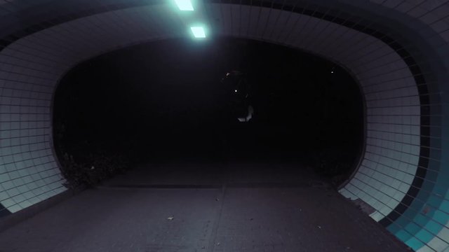 Walking through an urban tunnel at night.