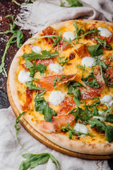 Pizza with ham, parmesan and arugula