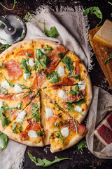Pizza with ham, parmesan and arugula