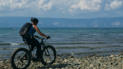 Fototapeta premium Fat bike also called fatbike or fat-tire bike in summer driving on the beach. The guy is going straight on the beach. On the sand on such a bike ride is not difficult.