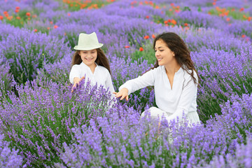 young woman and girl are in the lavender field, beautiful summer landscape with red poppy flowers