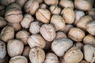 Backround of unpeeled english walnuts sold at local city market