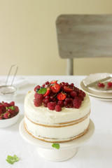 Summer home biscuit cake with curd cream, decorated with fresh berries of strawberries, raspberries and currants.