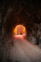 Stone Carved Tunnel and Red Sunset Light opening on Autumn Foliage.