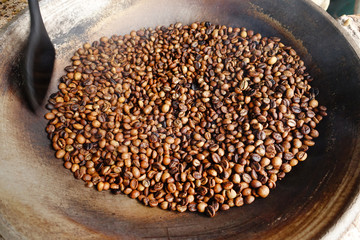 Coffee beans are roasting in pan. Traditional techniques.                         