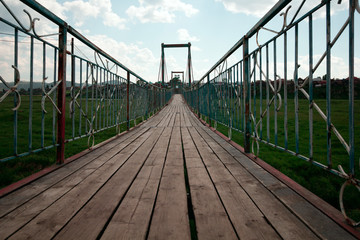 wooden  footbridge against blue summer sky in a park