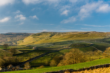 Obraz premium Farmland and limestone pavement in Yorkshire Dales National Park