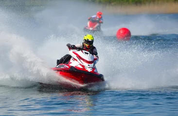 Foto auf Acrylglas Wasser Motorsport Jet-Ski-Rennfahrer bewegen sich mit hoher Geschwindigkeit und erzeugen viel Spray