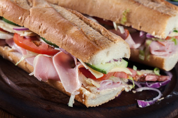 Submarine sandwiches with ham, cheese and vegetables