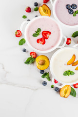 Summer healthy diet dinner, vegan food, dessert, various sweet creamy fruit & berry soups - strawberry, peach, blueberry, white marble background  top view copy space