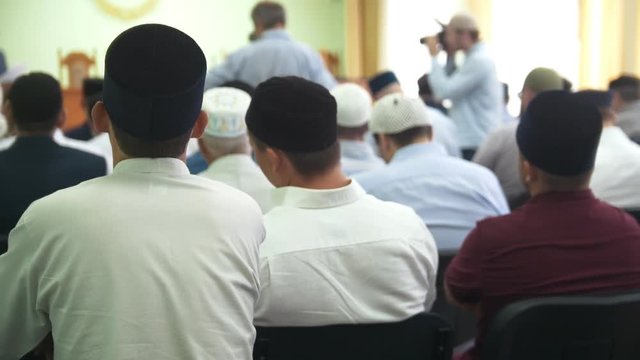 Rear view of muslim men sitting at the islamic conference
