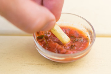 French fries are dipped in ketchup.