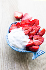 Strawberries with cream on a light background. Close-up. Selective focus.