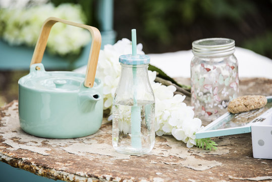Picnic table with jars, bottles and biscuits. Romantic outdoor conception.