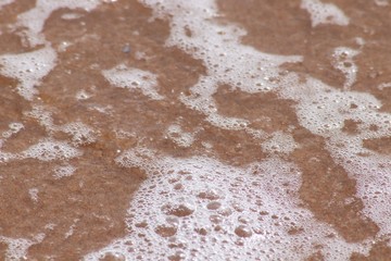 Bubbles in seawater on sand on beach