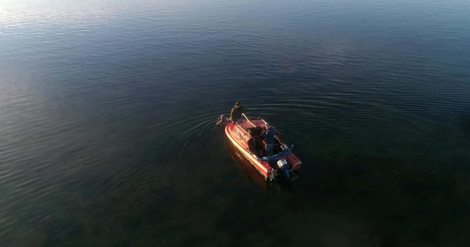 Divers boat C4K aerial view of a team of divers inspecting the clear waters of baltic sea at a wharf, on a sunny summer evening dusk, in Hanko, Finland