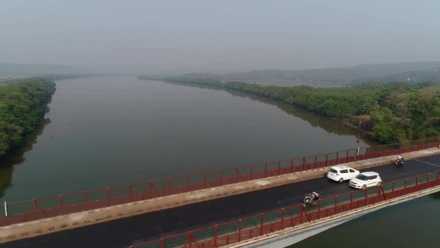 Aerial view. Flying over the bridge, cars moves on a large concrete bridge across the Zuari river in Goa, India. 
