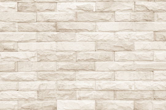 Fototapeta Cream and white brick wall texture background. Brickwork or stonework flooring interior rock old pattern clean concrete grid uneven bricks design stack.