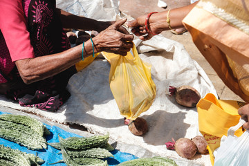 India. Indian people buy and sell fruits and vegetables on the market right on the ground, check...
