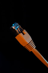 RJ 45 plug LAN ethernet network cable isolated on dark background.