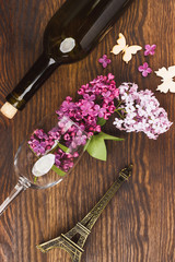 Obraz na płótnie Canvas Wineglass with violet lilacs and decorations