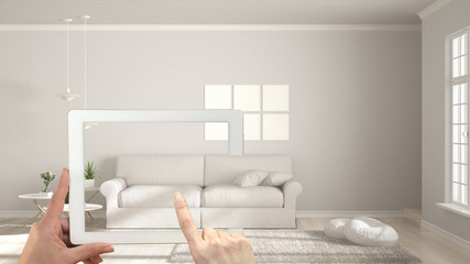 Augmented reality concept. Hand holding tablet with AR application used to simulate furniture and interior design products in real home, modern white living room