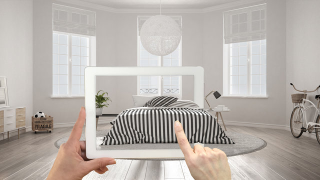 Augmented reality concept. Hand holding tablet with AR application used to simulate furniture and interior design products in real home, scandinavian bedroom