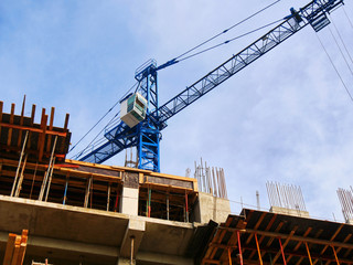 Fototapeta na wymiar Commercial construction project. Crane near building. Construction site background